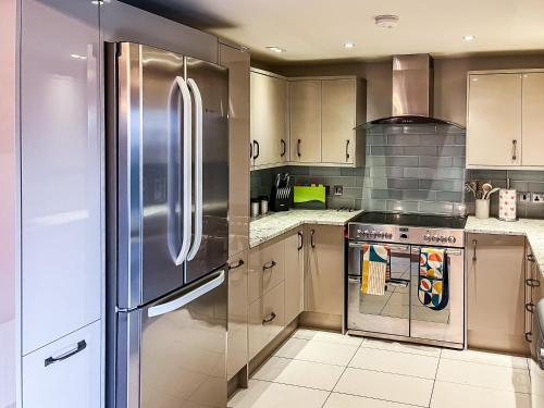 een keuken met een roestvrijstalen koelkast en kasten bij Valentines Cottage - Uk48509 in Kirk Hammerton