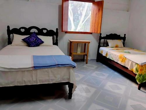 Un dormitorio con dos camas y una ventana. en Kóten Naj, en Chicanna