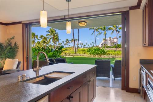 a kitchen with a sink and a view of the ocean at Popular Ground Floor with Extra Grassy Area - Beach Tower at Ko Olina Beach Villas Resort in Kapolei