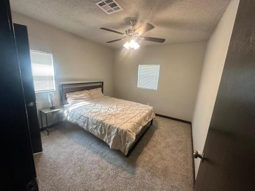 una camera da letto con un letto e un ventilatore a soffitto di The Relaxed Place 