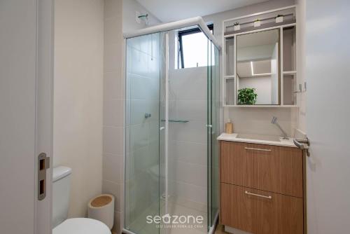 a bathroom with a shower and a toilet and a sink at Aptos completos em prédio com piscina a 400m da Praia de Piçarras - BACs in Piçarras