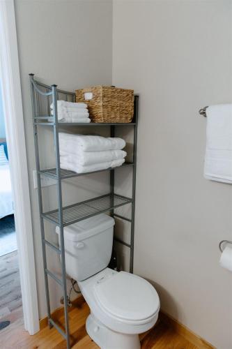 a bathroom with a toilet and a rack with towels at Willow South Cottage in Moscow