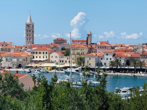 a city with boats docked in a harbor at Rooms by the sea Rab - 18786 in Rab