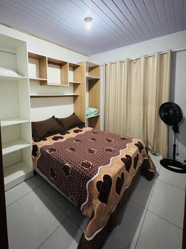 una camera con letto in una stanza con scaffali di Apartamento 2 a Arroio do Silva