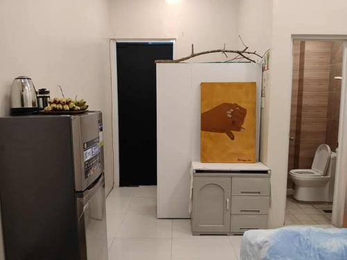 Un baño con inodoro y un cuadro en la pared. en Xybel Studio, en Baguio