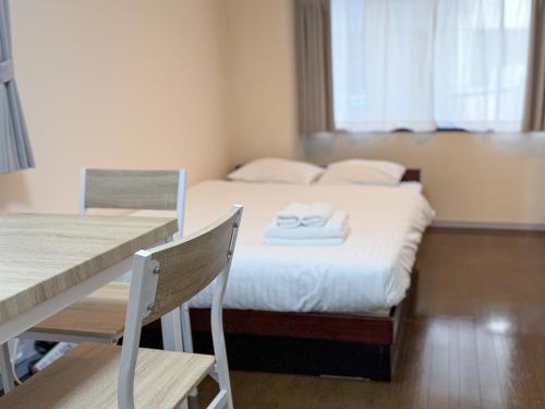 SUNCOURT Komachi في هيروشيما: غرفة نوم بها سرير عليه منشفتان