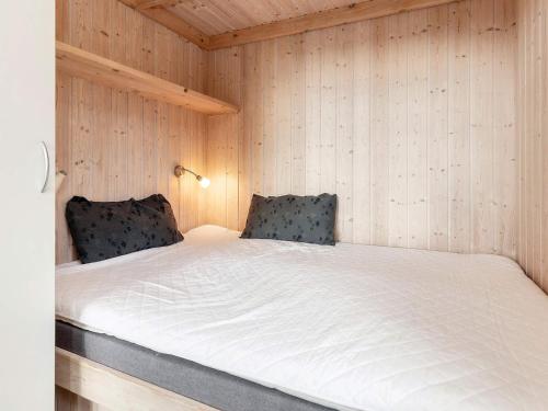 Posto letto in camera con pareti in legno. di vast cabin in camping resort a Sønder Rubjerg