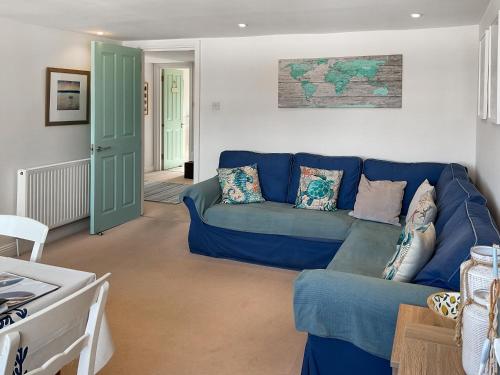 ein Wohnzimmer mit einem blauen Sofa und einem Tisch in der Unterkunft Sandbourne in Bournemouth
