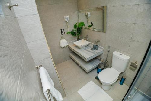 un baño con inodoro y lavabo en The KMT Collection Hotel, en El Cairo