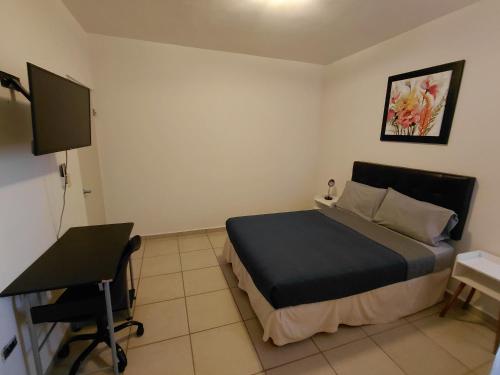 a bedroom with a bed and a desk and a computer at Casa condominio de la Rueda in La Paz