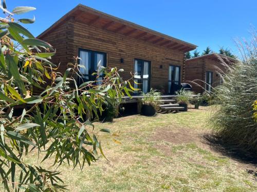 una casa de ladrillo con un jardín delante de ella en Complejo de Cabañas Pura Vida, en Balneario Reta