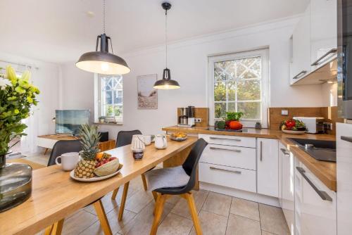 a kitchen with a wooden table and chairs at Whg Dynamique in Zingst