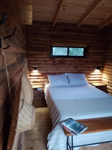 a bedroom with a bed in a wooden cabin at Complejo de Cabañas Pura Vida in Balneario Reta