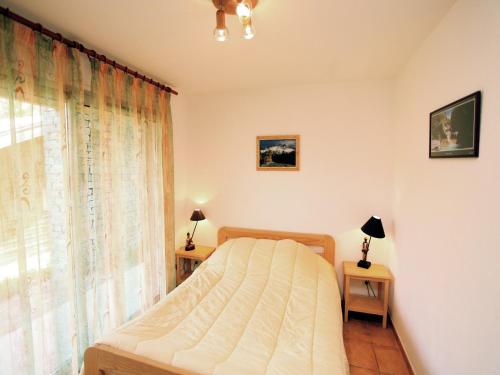 a bedroom with a bed and a window at Chalet in Villarodin near Lake in La Norma