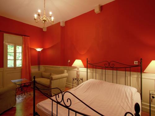 1 dormitorio con paredes rojas, 1 cama y 1 silla en House in France with Pool and Views, en Serrières-en-Chautagne