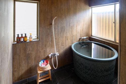 a bathroom with a tub and a window at Guest House DAN 団 in Yokohama