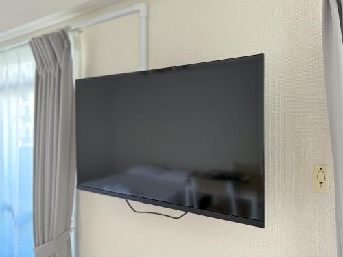 a flat screen tv hanging on a wall at SUNCOURT Komachi in Hiroshima