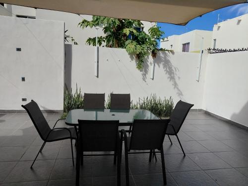 a glass table and chairs on a patio at Casa condominio de la Rueda in La Paz