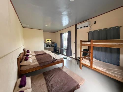 une chambre avec trois lits superposés dans l'établissement R&C Transient Extension, à El Nido