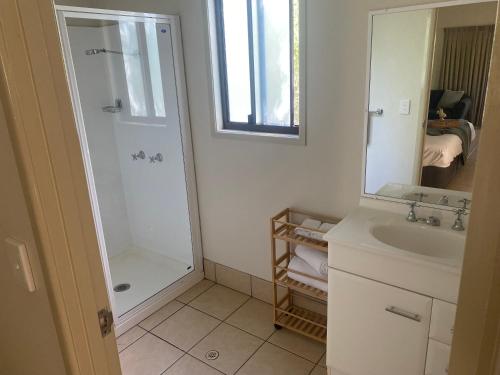 洛坎普顿卡普里可恩石窟酒店的浴室里有淋浴、洗手池和镜子。