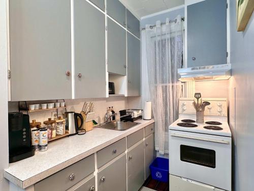 a kitchen with white cabinets and a sink and a stove at The Salt Soul Suite Cozy Apt 5 in Bridgewater