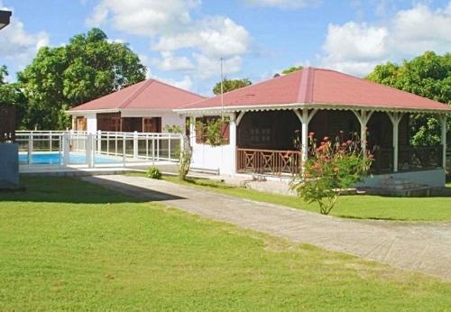 a house with a swimming pool in a yard at Gîtes du Domaine de la Canne à Sucre in Anse-Bertrand