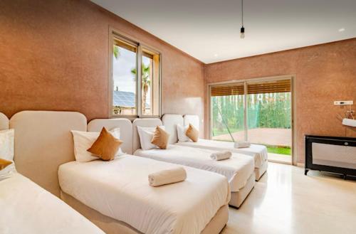 Oulad MazougVilla privée sans vis-à-vis,Padel,Tennis, Five的带三张床和壁炉的客房