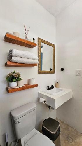 a bathroom with a white toilet and a sink at Apartment with jacuzzi and beach club access in Telchac Puerto