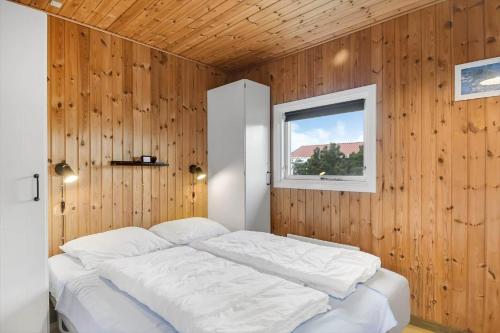 哈博尔163-Harboore-Vejlby-Klit-47的卧室配有一张白色的木墙床