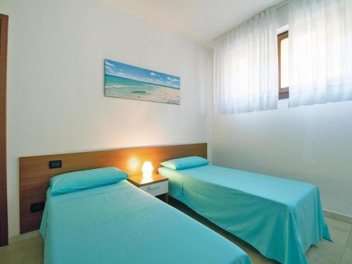 a hotel room with two beds and a window at Apartment with garden in Villasimius in Villasimius