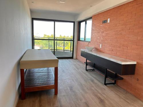 una grande stanza con una scrivania e un pianoforte di FLAT Beira Mar Tamandare a Tamandaré