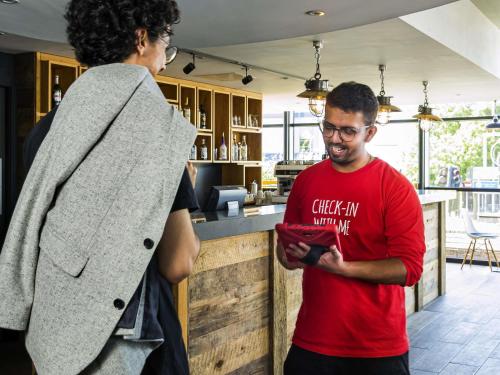 um homem e uma mulher a olhar para um telemóvel em ibis Leicester em Leicester