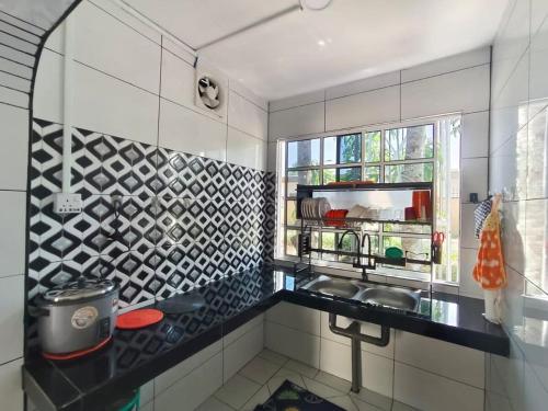a kitchen with a sink and a window at Princess Iris Homestay in Penampang