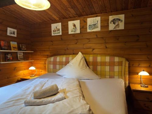a bedroom with a bed in a wooden cabin at Gemütliches Blockhaus in Eschede bei Lüneburg in Eschede