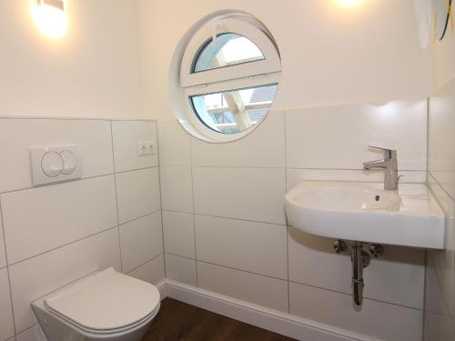 a white bathroom with a sink and a toilet at Reihenhaus Reiterchalet in Wendorf in Wendorf