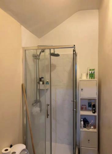 a shower with a glass door in a bathroom at Lubona Stirchley Guest House in Birmingham