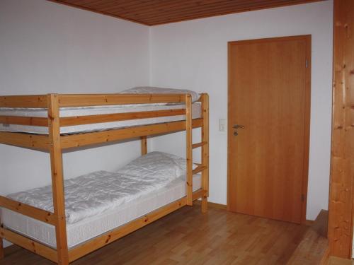 a bunk bed room with two bunk beds and a door at Gemütliche tierfreundliche Wohnung in Huddingen in Gellershausen