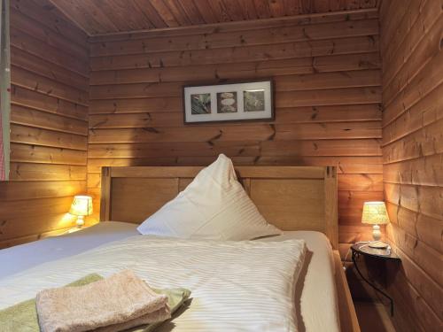 a bedroom with a bed in a wooden wall at Charmantes Ferienhaus mit Terrasse in der Südheide in Eschede