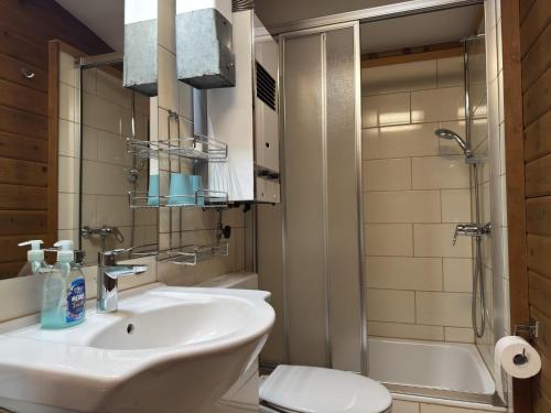 a bathroom with a sink and a toilet and a tub at Charmantes Ferienhaus mit Terrasse in der Südheide in Eschede