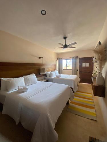 a bedroom with two beds and a ceiling fan at Casa Hamaca Nayarit in Chacala