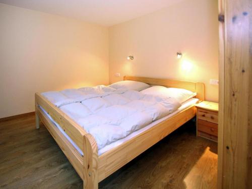 ein Schlafzimmer mit einem großen Bett mit weißer Bettwäsche in der Unterkunft Feriendorf am Weinberg, Dobbrikow in Dobbrikow