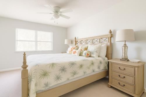 a bedroom with a bed with a fan and a nightstand at Beachside Bliss - Neptune Nook Unit 2 in Jacksonville Beach