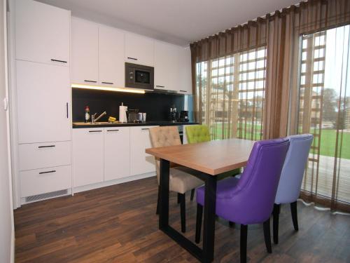 a kitchen with a wooden table and purple chairs at Reihenhaus Reiterchalet in Wendorf in Wendorf