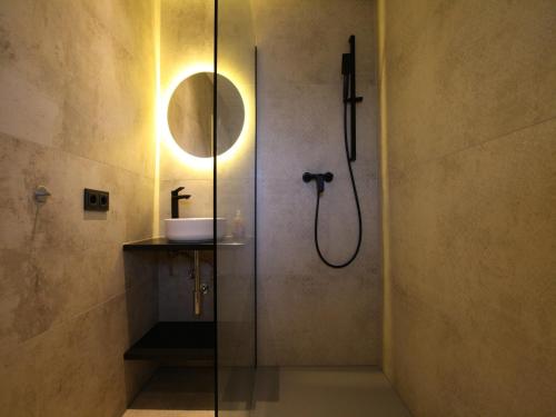 een badkamer met een douche met wastafel en spiegel bij Ferienhaus direkt an der Spree in Frauenberg