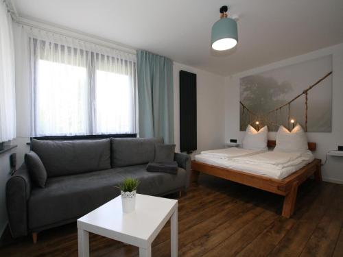 een woonkamer met een bank en een bed bij Ferienhaus direkt an der Spree in Frauenberg