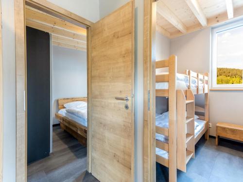 HallschlagLakeside Bungalow in Hallschlag的一间有两张双层床和一扇带梯子的门的房间