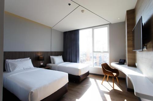 Una cama o camas en una habitación de Jazzotel Bangkok