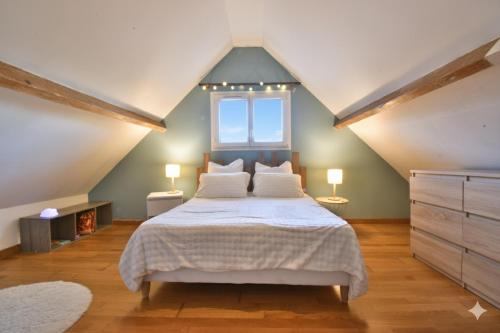 a bedroom with a large bed in a attic at Le Cocon Bleu in Saint-Pierre-en-Port