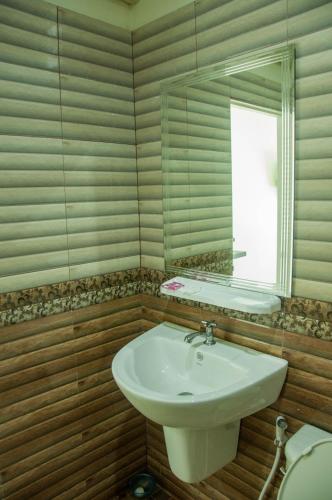 a bathroom with a sink and a mirror and a toilet at Pleai Ta Lea Resort in Chao Lao Beach