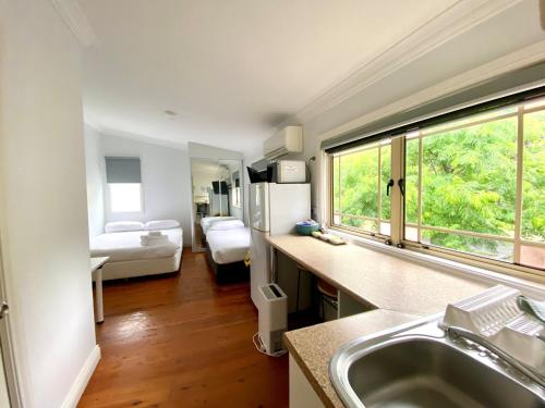 a kitchen with a sink and a living room at Royal Far West Lodge in Sydney